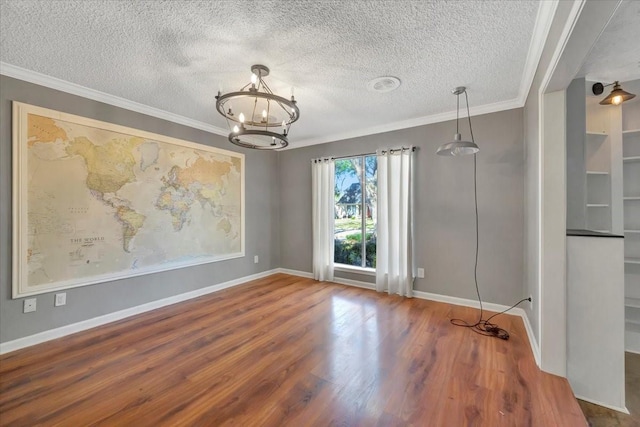 unfurnished room with hardwood / wood-style floors, a textured ceiling, crown molding, and a chandelier