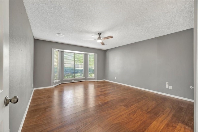 spare room with a textured ceiling, hardwood / wood-style flooring, and ceiling fan