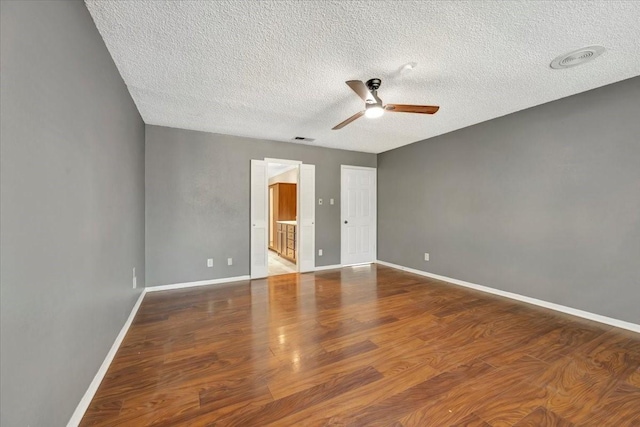 empty room with hardwood / wood-style floors, a textured ceiling, and ceiling fan