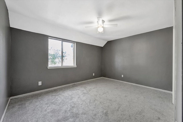 carpeted empty room featuring ceiling fan and lofted ceiling