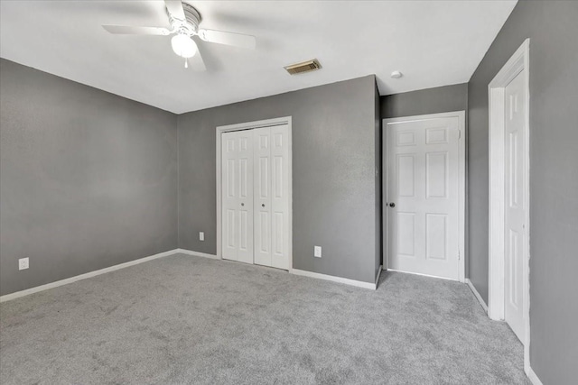 unfurnished bedroom with ceiling fan, a closet, and light carpet