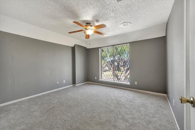 carpeted spare room featuring a textured ceiling and ceiling fan