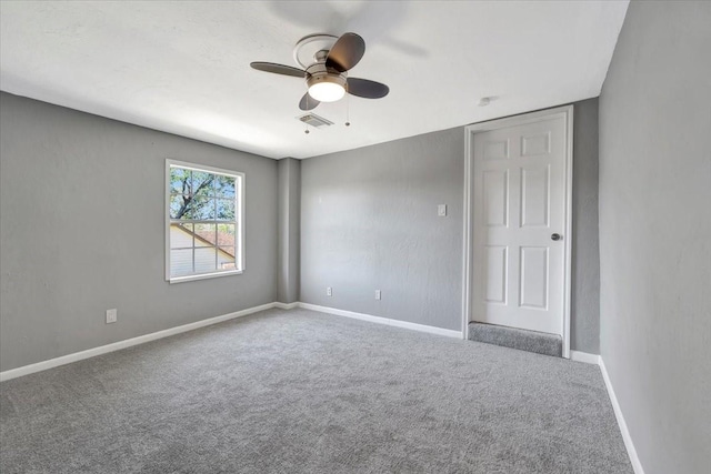 carpeted empty room featuring ceiling fan