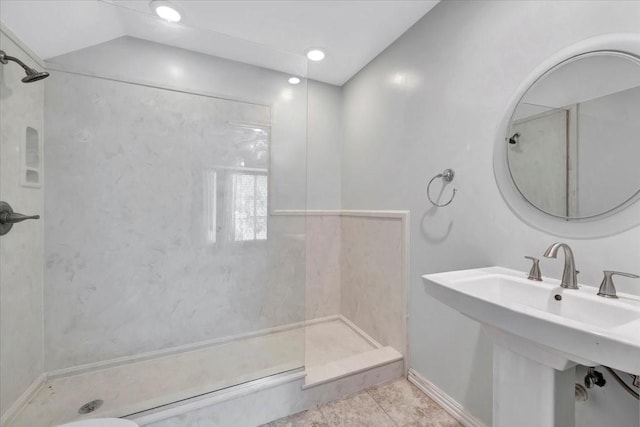 bathroom featuring a tile shower and sink