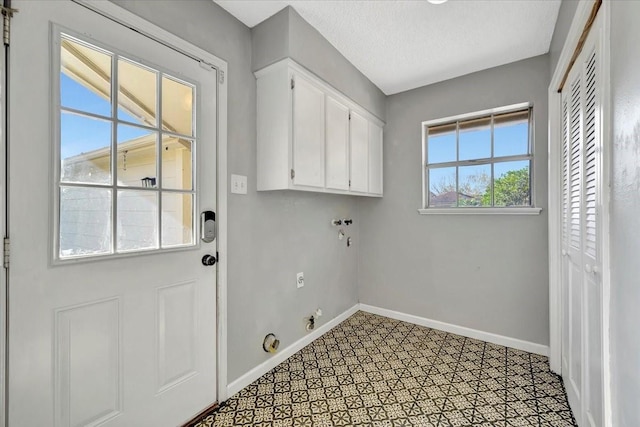 laundry area featuring cabinets and a textured ceiling