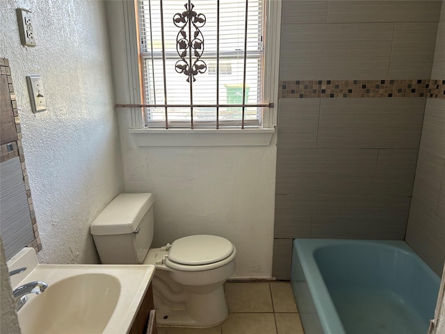 bathroom with tile patterned flooring, vanity, toilet, and a washtub