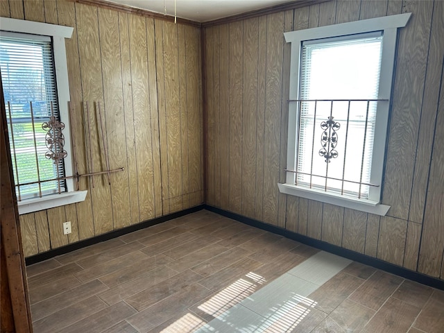 spare room with a wealth of natural light and wood walls