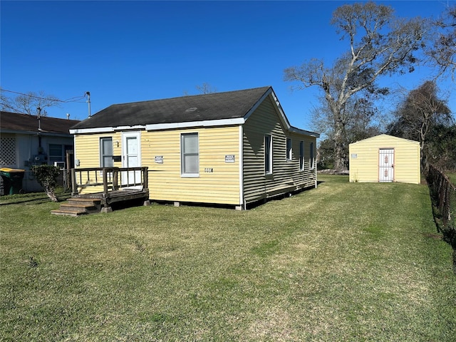 back of house featuring a yard and a shed