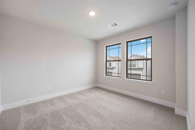 spare room featuring light colored carpet