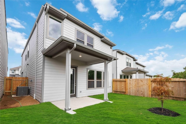 back of house with a lawn, cooling unit, and a patio