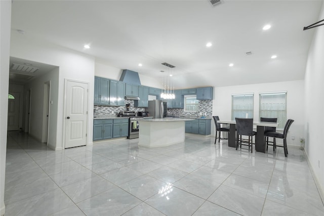 kitchen featuring pendant lighting, backsplash, a kitchen island, and stainless steel appliances