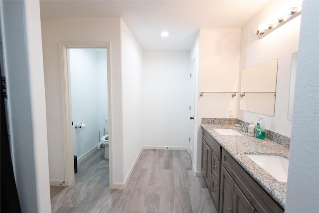 bathroom featuring hardwood / wood-style flooring, vanity, and toilet