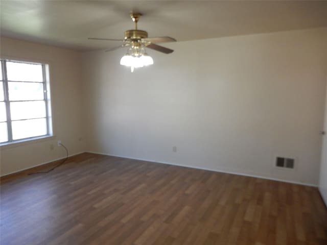 spare room featuring ceiling fan, a healthy amount of sunlight, and dark hardwood / wood-style floors