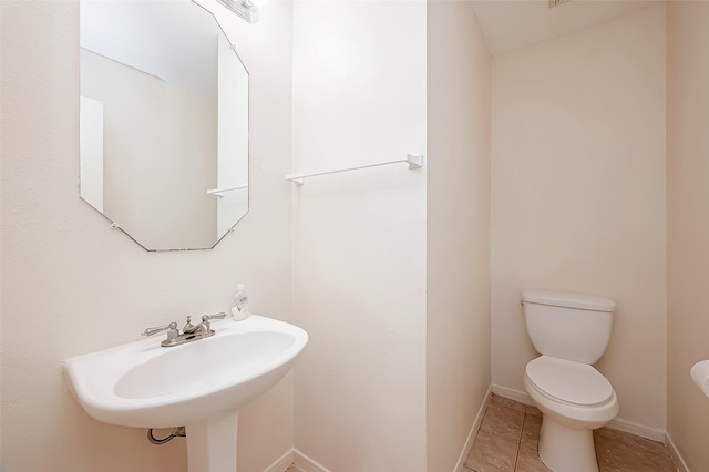 bathroom featuring tile patterned flooring, toilet, and sink