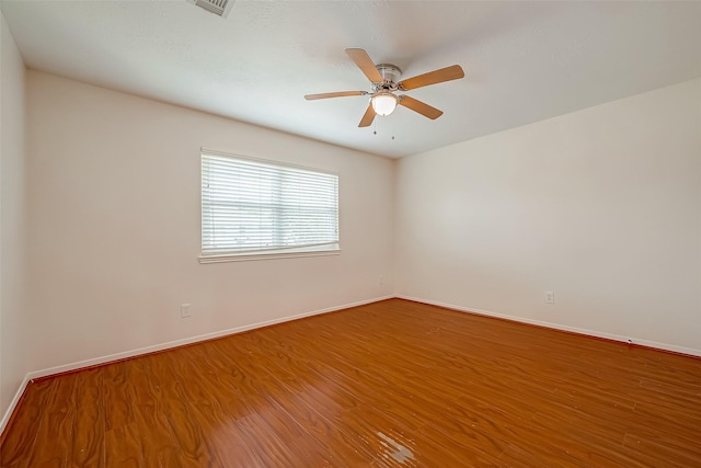 empty room with hardwood / wood-style floors and ceiling fan