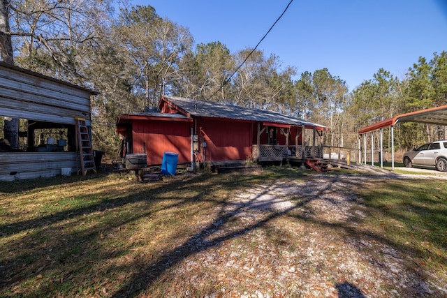 exterior space with a carport and a yard