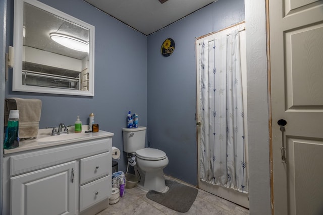 bathroom with toilet, vanity, and tile patterned floors