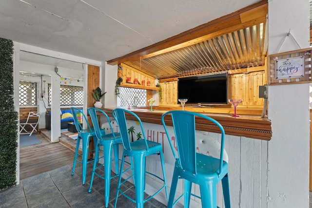 kitchen with a kitchen breakfast bar and dark tile patterned flooring