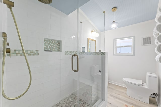 bathroom with crown molding, toilet, hardwood / wood-style floors, and walk in shower