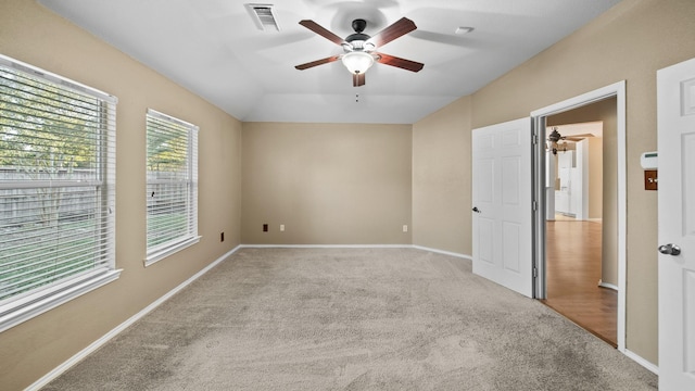 carpeted spare room featuring lofted ceiling and ceiling fan