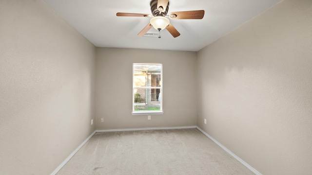 spare room with ceiling fan and light colored carpet