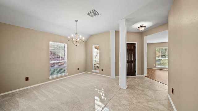 carpeted spare room with lofted ceiling, plenty of natural light, and a notable chandelier