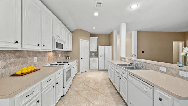 kitchen with sink, white appliances, light tile patterned floors, white cabinetry, and tasteful backsplash