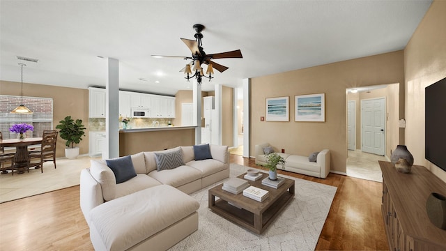 living room with ceiling fan and light wood-type flooring