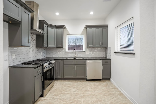 kitchen with dishwashing machine, sink, wall chimney range hood, stainless steel gas stove, and gray cabinets