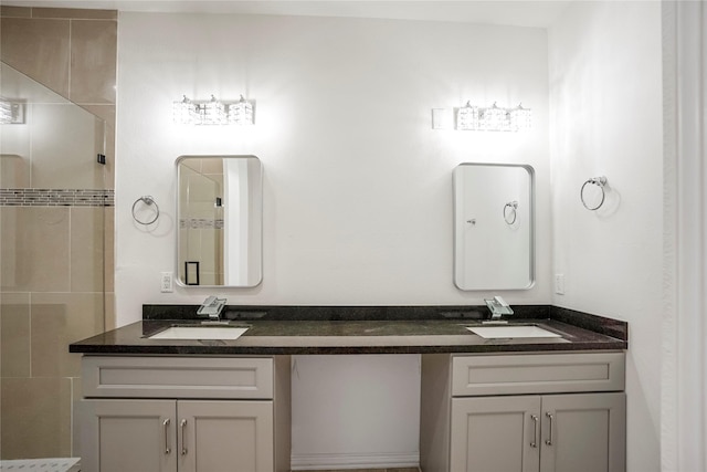 bathroom featuring tiled shower and vanity