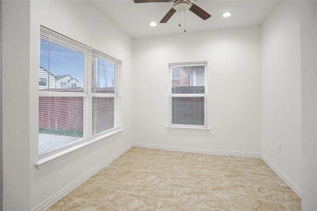 spare room featuring ceiling fan and plenty of natural light