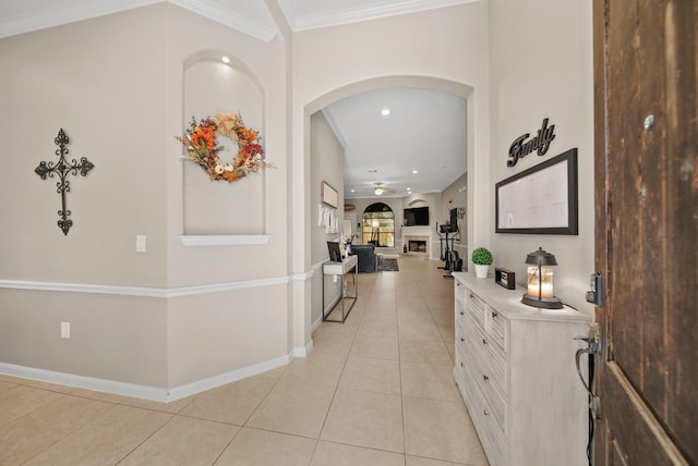 hallway with ornamental molding and light tile patterned flooring