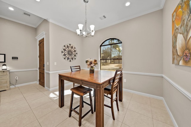 dining room with light tile patterned floors, ornamental molding, and a notable chandelier