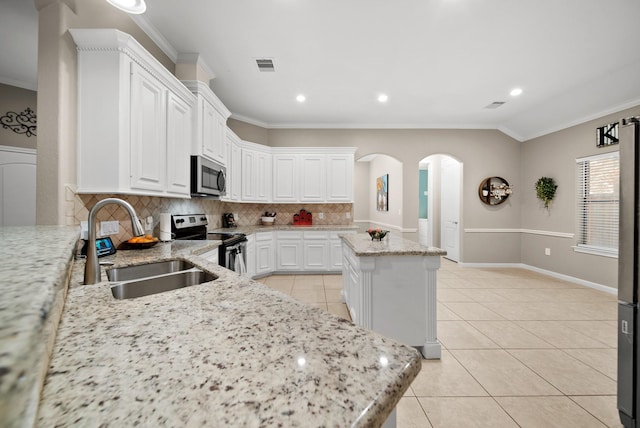 kitchen with white cabinetry, light stone countertops, sink, a center island, and appliances with stainless steel finishes