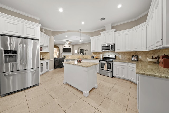 kitchen with white cabinets, decorative backsplash, and stainless steel appliances