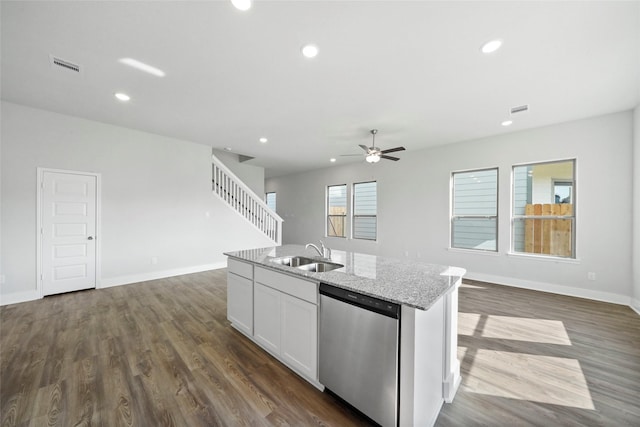 kitchen featuring sink, light stone counters, stainless steel dishwasher, a center island with sink, and white cabinets