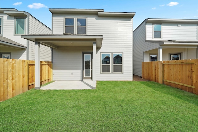 rear view of house with a patio and a lawn