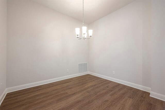 unfurnished room with dark hardwood / wood-style floors, vaulted ceiling, and a notable chandelier