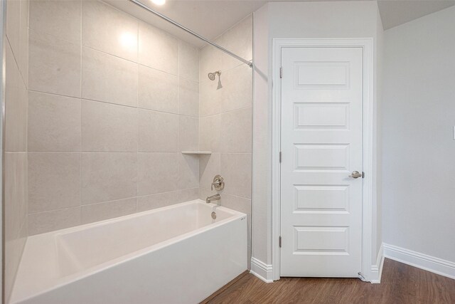 bathroom with wood-type flooring and tiled shower / bath