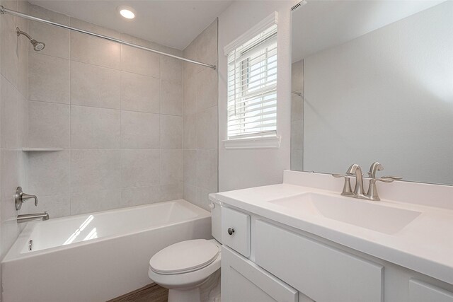 full bathroom featuring toilet, vanity, and tiled shower / bath