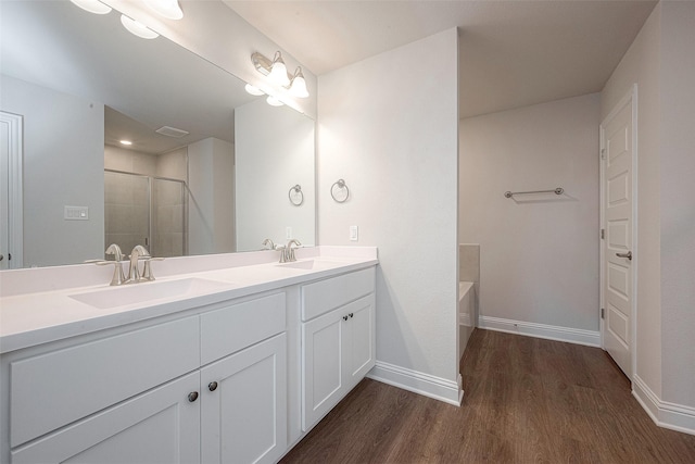 bathroom featuring hardwood / wood-style floors, vanity, and separate shower and tub