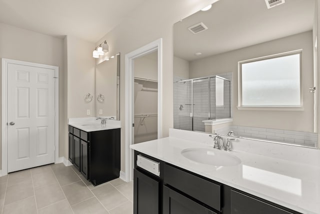 bathroom featuring tile patterned flooring, vanity, and walk in shower