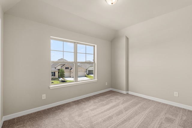 empty room with light colored carpet and lofted ceiling