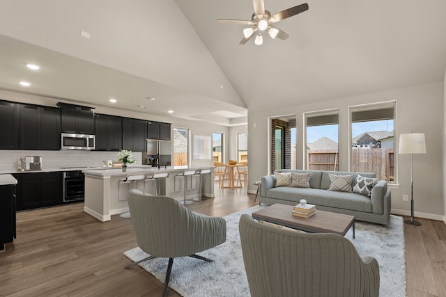 living room featuring light wood-type flooring, high vaulted ceiling, plenty of natural light, and ceiling fan