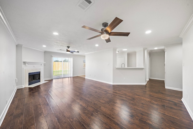 unfurnished living room featuring crown molding, ceiling fan, and dark hardwood / wood-style floors