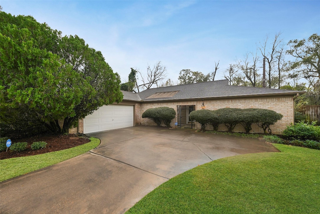 ranch-style house with a front yard and a garage