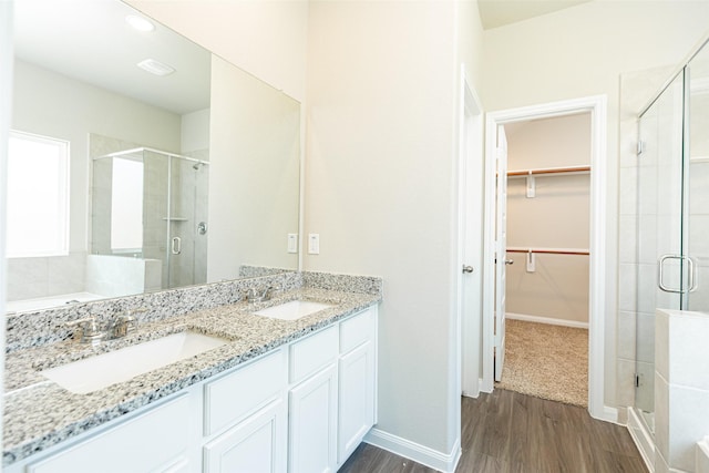 bathroom featuring wood-type flooring, an enclosed shower, and vanity