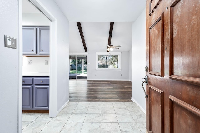 foyer entrance featuring ceiling fan, light tile patterned flooring, and lofted ceiling with beams