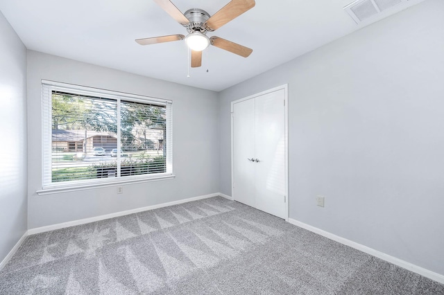 carpeted spare room with ceiling fan