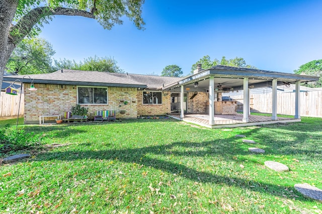 rear view of property with ceiling fan, a yard, and a patio